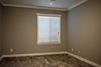 Bedroom with faux wood blinds and neutral carpet